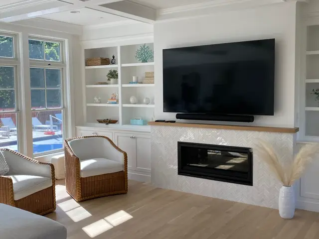 Fireplace with a brick-look tile surround flanked by built-in shelving