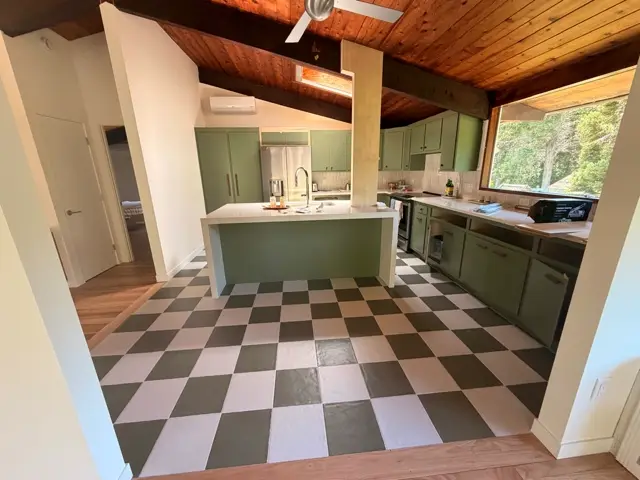 Kitchen with sage green cabinetry and a black and white checkerboard floor