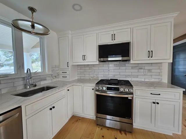 White kitchen with a subway tile backsplash and a bright window over the sink