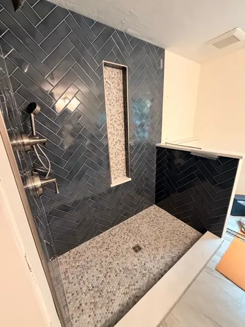 Charcoal herringbone tile shower with brushed nickel fixtures
