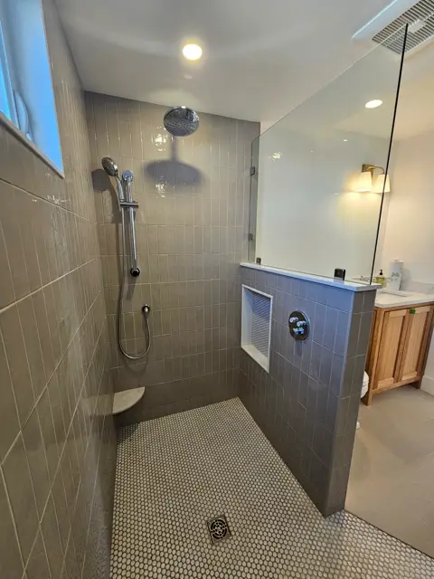 Walk-through shower with a half wall and a recessed tile niche