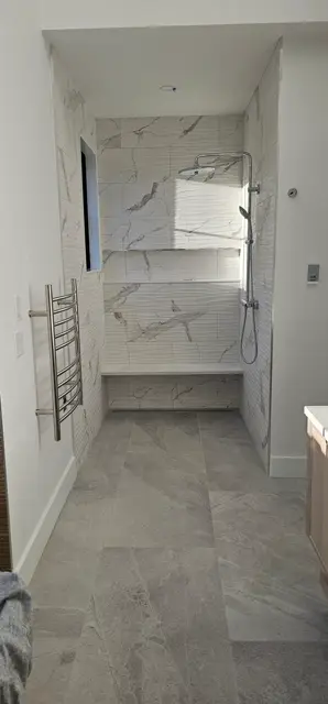 Marble tile shower with a built-in bench and dual shower heads